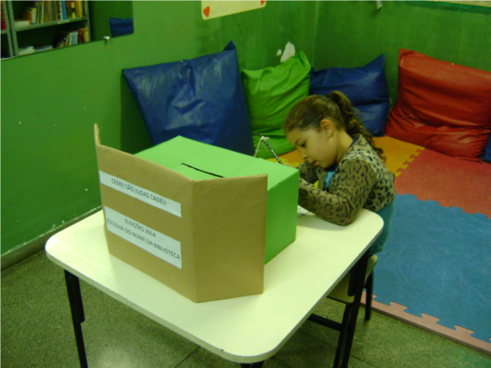 Aluna votando para escolher o nome da biblioteca